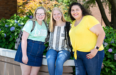 students sitting on a wall