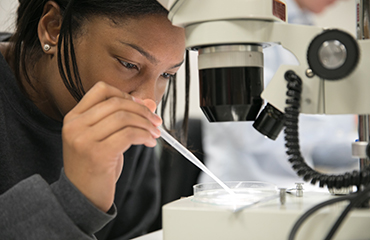 student with microscope